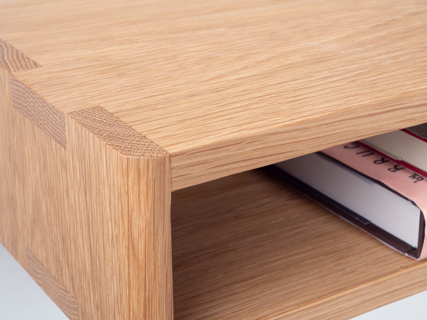 Mesa Bedside Shelf in White Oak pictured with detailed view of the joinery and two books. Designed and made by Hey, Porter.